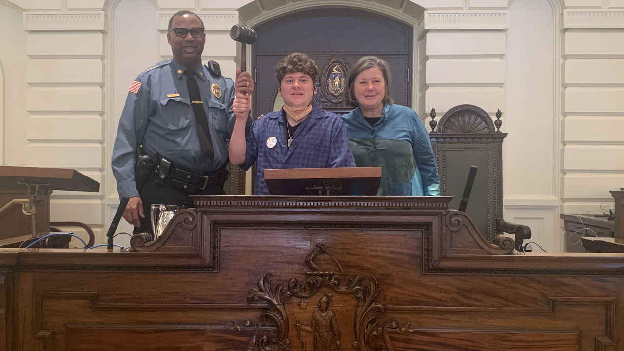 UMass Police Chief Tyrone Parham, Max Callahan and Senator Comerford stand at the Massachusetts Senate Rostrum